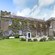Wisteria blooming on the vines covering the façade of an old stone estate
